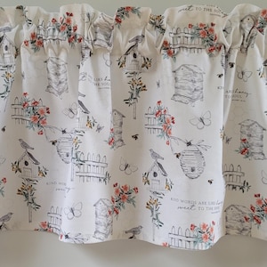 May include: White valance featuring a pattern of beehives, birdhouses, flowers, butterflies, and bees. The design includes the text "Kind words are like honey, sweet to the soul." The valance has a ruffled top edge.