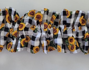 Könnte beinhalten: Schwarz-weiß kariertes Stoff mit einem Sonnenblumenmuster. Der Stoff ist gerafft und gekräuselt.