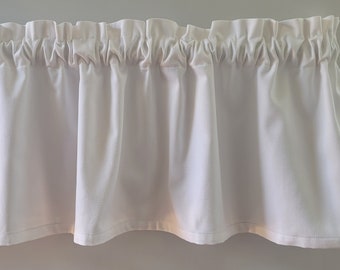 Pode incluir: Valance branca com uma parte superior franjada e uma borda inferior reta. A valance é feita de um tecido branco macio.