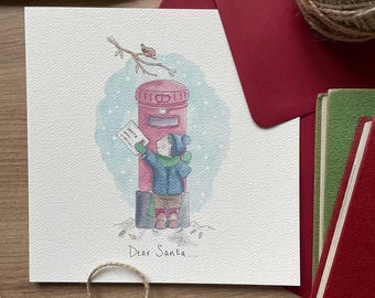 May include: A watercolor Christmas card featuring a child posting a letter to Santa in a red mailbox. The card has the text "Dear Santa..." at the bottom. A red envelope and green card are in the background.
