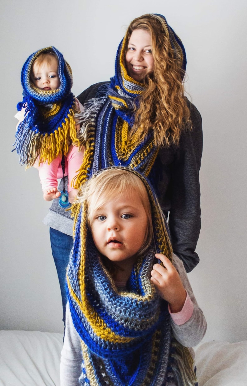 Pode incluir: Duas crian&ccedil;as usando cachec&oacute;is de croch&ecirc; azul, amarelo e cinza com franjas. Os cachec&oacute;is s&atilde;o usados como capuzes. As crian&ccedil;as est&atilde;o sorrindo.