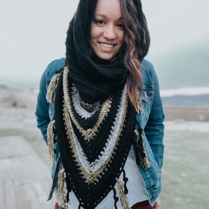Pode incluir: Um xale de croch&ecirc; preto e dourado com franjas. O xale &eacute; usado por uma pessoa com cabelo castanho comprido e uma jaqueta de ganga.