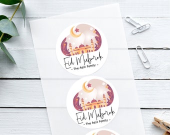 May include: Three round stickers with a white background and a colorful illustration of a mosque with a crescent moon and star. The text "Eid Mubarak - The Aziz Family -" is printed on each sticker.