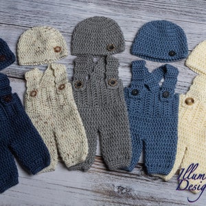 May include: Five sets of crocheted baby overalls and hats in different colors. The overalls are in blue, cream, and gray. The hats are in the same colors. Each set has a button on the hat and two buttons on the overalls.