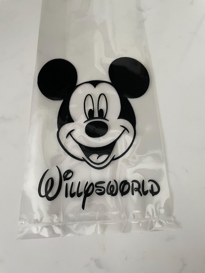 May include: Clear plastic bag featuring a black and white Mickey Mouse graphic and the text "WillysWorld" in a script font. The bag is sealed at the bottom and appears to be empty.