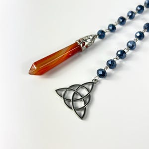 Carnelian dowsing pendulum, triquetra, rosary witch ladder and divination