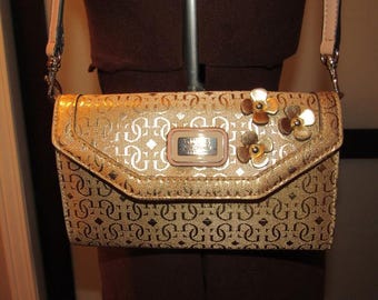 Cartera de mano Guess con correa. Color dorado.