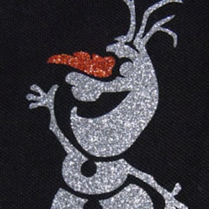 Könnte beinhalten: Ein silberner Glitzer-Schneemann mit einer roten Karottennase und schwarzen Augen. Der Schneemann steht mit ausgestreckten Armen.