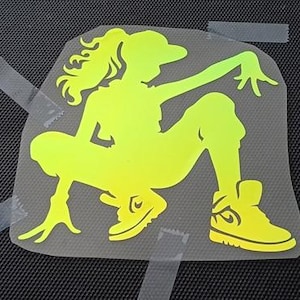 Puede incluir: Una silueta amarilla de una persona en posición de cuclillas, con un sombrero y zapatillas deportivas. La silueta está sobre un fondo claro.