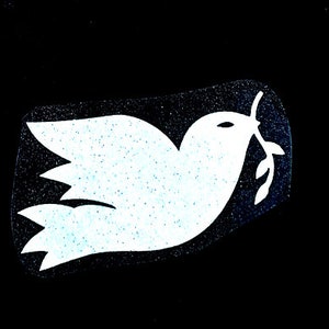May include: A white dove with an olive branch in its beak, symbolizing peace. The dove is silhouetted against a black background.