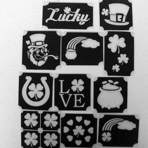 Könnte beinhalten: Set mit 10 schwarzen und weißen Schablonen mit irischen Motiven, darunter ein Kobold, Kleeblätter, ein Topf mit Gold, ein Regenbogen, ein Hufeisen und das Wort "Lucky".