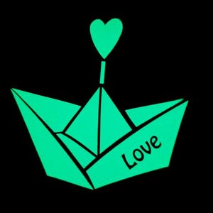 May include: A luminous green paper boat with a heart-shaped sail and the word "Love" on the side, set against a black backdrop. The origami-style boat is a symbol of affection and romance.
