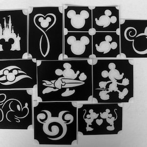 Op de afbeelding: Set van 10 zwarte en witte stencils met verschillende Disney-figuren, waaronder Mickey Mouse, Minnie Mouse en het Disney-kasteel. De stencils zijn perfect voor knutselen, decoreren en het creëren van unieke ontwerpen.
