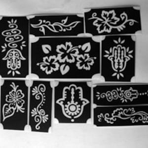 May include: Set of 10 black henna tattoo stencils with various designs, including floral, paisley, and hamsa hand patterns.