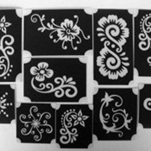 May include: Set of ten black and white henna tattoo stencils with floral and swirl designs.