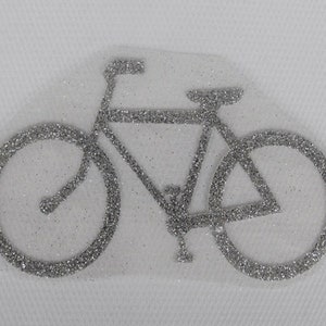 May include: A silver glitter bicycle design iron-on patch. The bicycle has two wheels, handlebars, and a seat.
