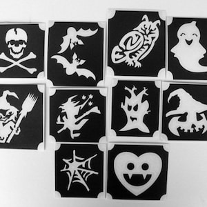 May include: A collection of Halloween-themed stencils featuring various designs. The stencils include a skull and crossbones, bats, an owl, a ghost, a witch with a broom, a witch flying, a spooky tree, a jack-o'-lantern, a spider web, and a heart-shaped vampire.
