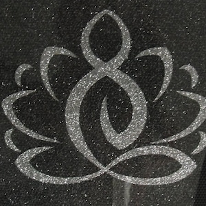 Könnte beinhalten: Ein silbernes Glitzer-Lotusblüten-Design auf schwarzem Hintergrund.
