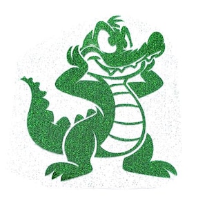 May include: Green glitter alligator cartoon character with a toothy grin. The alligator is standing on its hind legs with its arms crossed.