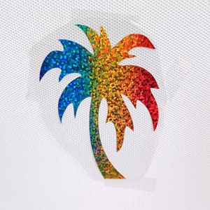 Könnte beinhalten: Ein ausgeschnittener Palmenbaum aus Regenbogen-Glitzer. Die Palme ist ein beliebtes tropisches Designelement.