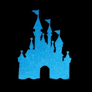 May include: A blue glitter silhouette of a castle with multiple towers and spires. The castle has a large, open archway in the center.