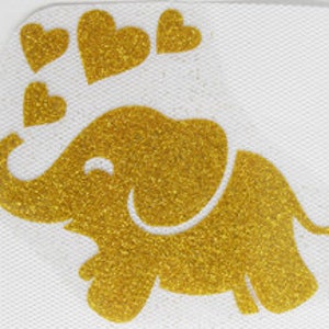 Könnte beinhalten: Ein goldener Glitzer-Elefant mit einem lächelnden Gesicht und vier goldenen Glitzer-Herzen darüber.