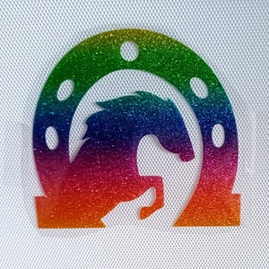 May include: A rainbow glitter horseshoe with a horse silhouette inside. The horseshoe is a popular symbol of good luck.