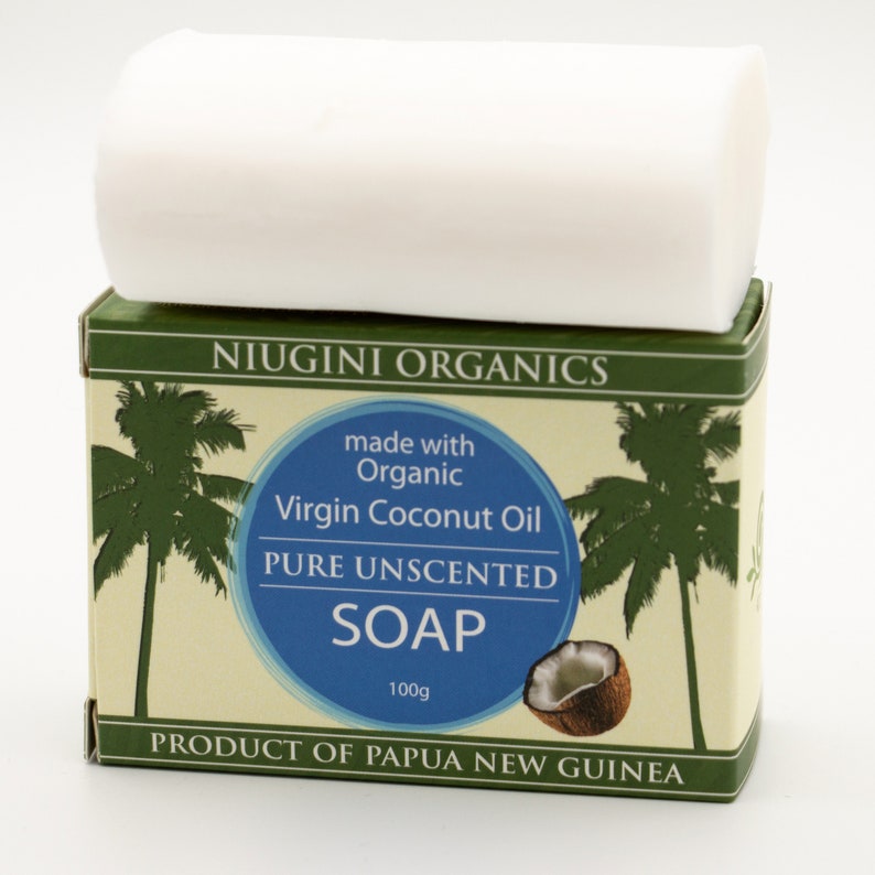 May include: A bar of white soap in a green and white box. The box says "Niugini Organics" and "Made with Organic Virgin Coconut Oil Pure Unscented Soap 100g Product of Papua New Guinea".