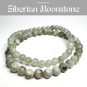 May include: A beaded bracelet made of round, translucent, greyish-green Siberian Moonstone beads. The stones have a smooth, polished finish with subtle internal variations. The text Mettā Maitrī and Siberian Moonstone is visible at the top.