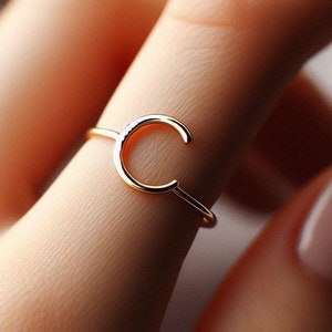 Op de afbeelding: Een gouden ring met een simpel, open 'C'-ontwerp.