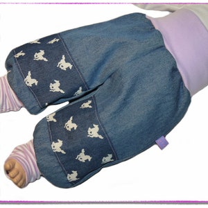 Pu&ograve; includere: Pantaloni per neonati in denim blu con stampa di coniglietto bianco e fascia in lavanda.