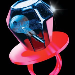 May include: A vibrant, digitally rendered image of a ring-shaped candy with a large, faceted gem. Inside the gem is a key. The ring and gem are red and pink, set against a black background. A bright white light emanates from the gem.