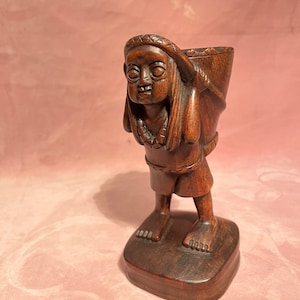 Dame de sculpture en bois indonésienne vintage portant un panier.