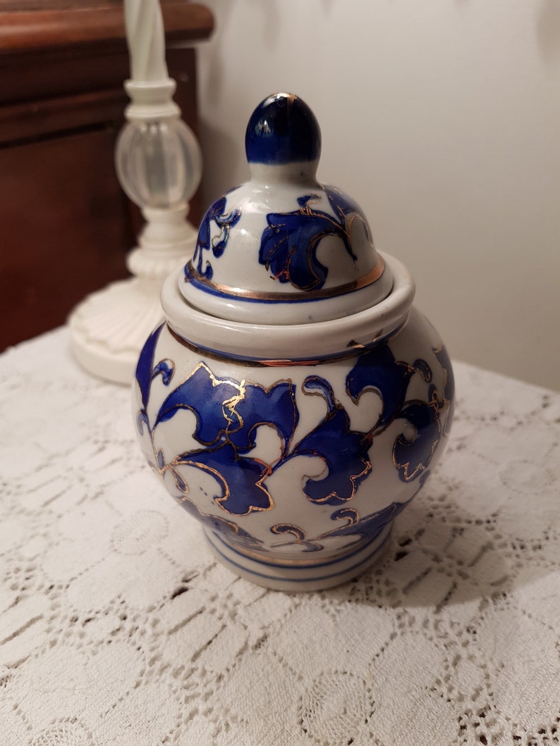 Vintage small lidded pot.Porcelain whit blue and gold flowers.