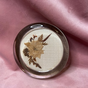 Old unique paperweight with dry flowers.