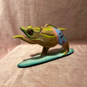 Prachtige Vintage uit hout gesneden kikker op een surfplank.
