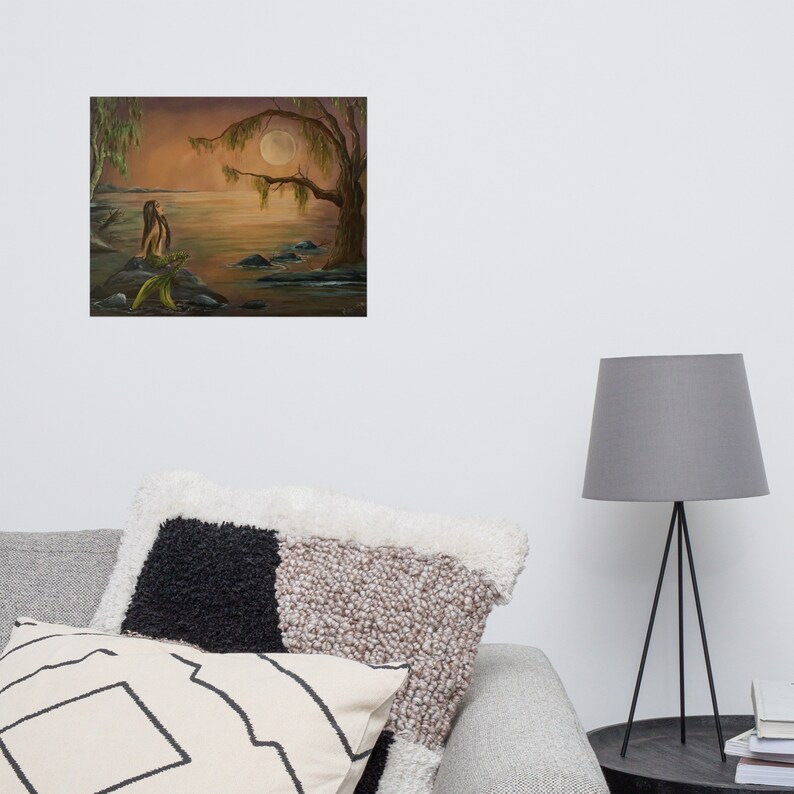Acrylic painting of a mermaid sitting in the moonlight on a rock.  Water surrounds her. This painting was created by artist, Raine.  The tone of the artwork is warm and peaceful.  It is created with oranges, blues, green and browns. It is fantasy art