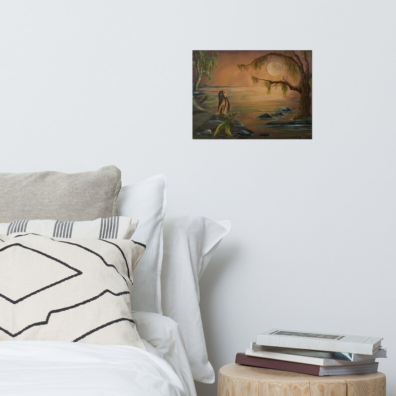 Acrylic painting of a mermaid sitting in the moonlight on a rock.  Water surrounds her. This painting was created by artist, Raine.  The tone of the artwork is warm and peaceful.  It is created with oranges, blues, green and browns. It is fantasy art