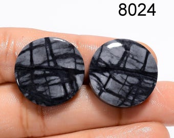 May include: Two round, polished gemstones with a gray and black web-like pattern. The gemstones are held in a hand. The number "8024" is printed in black at the top of the image.