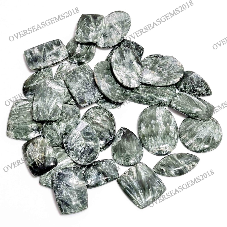 May include: A collection of green and silver gemstone cabochons. The stones have a unique, swirling pattern and are perfect for jewelry making.
