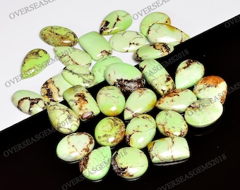 Op de afbeelding: Een verzameling van 20 groene en bruine edelsteen cabochons. De stenen zijn peervormig en ovaalvormig. De stenen zijn glad en gepolijst.