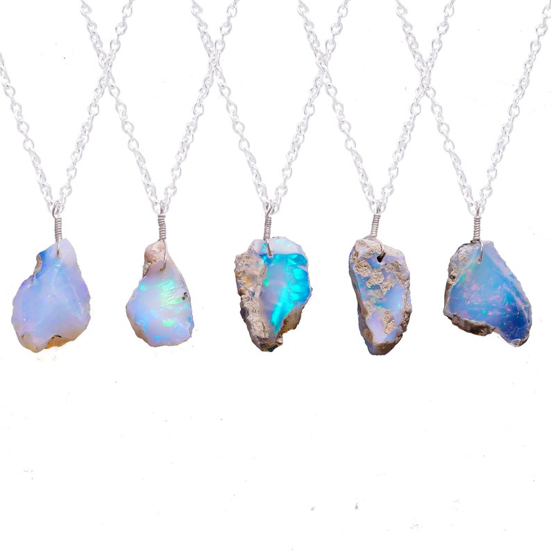 May include: Five silver necklaces with raw opal pendants. The opals are various shades of blue, white, and grey.