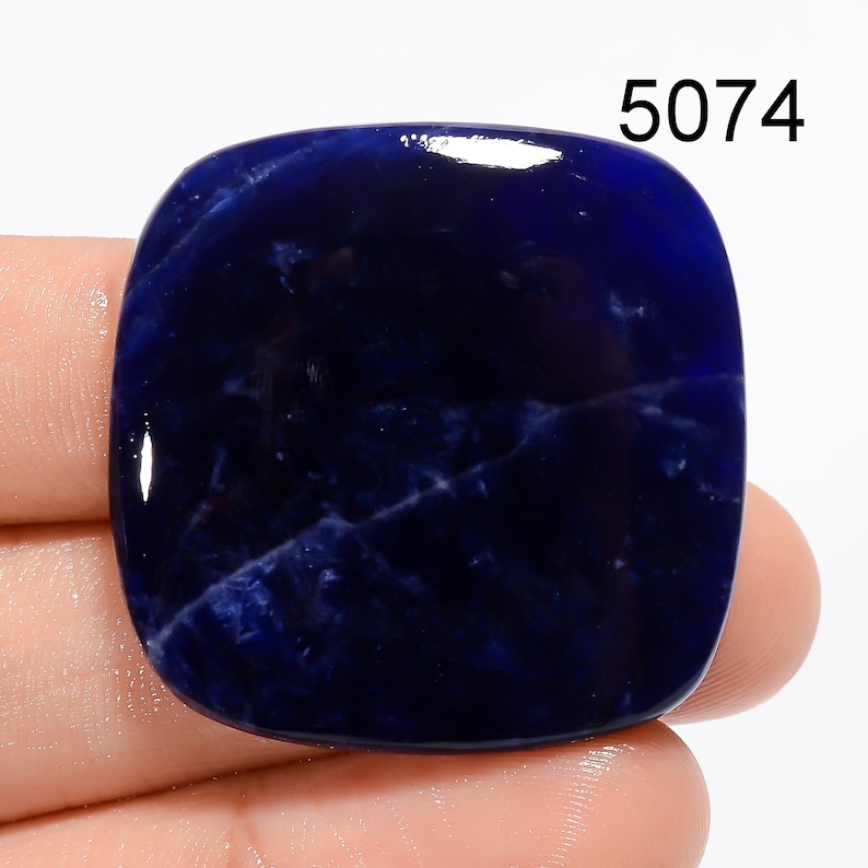 Op de afbeelding: Een diepblauwe, gepolijste, vierkante cabochon edelsteen met witte aderen. De edelsteen is ongeveer 5 cm groot.
