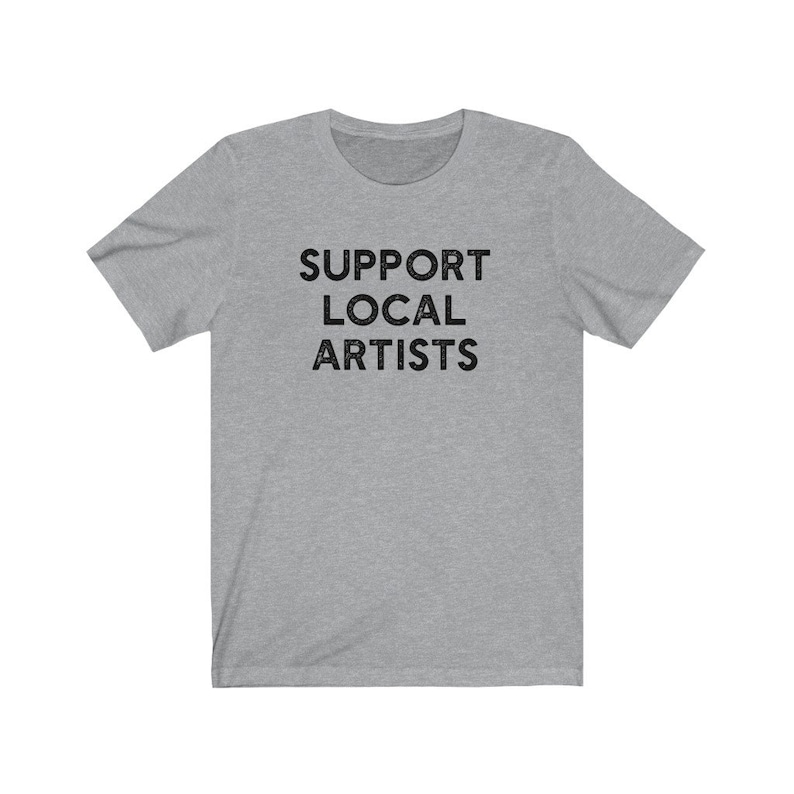 May include: A heather gray t-shirt with the text "SUPPORT LOCAL ARTISTS" printed in black.