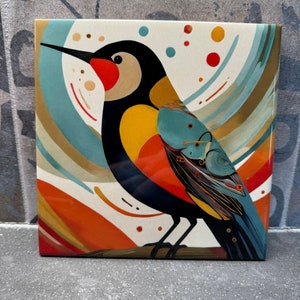 Puede incluir: Una pintura abstracta colorida de un pájaro con un diseño negro, amarillo, rojo y azul sobre un fondo blanco con remolinos dorados y azules.