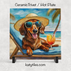 May include: Ceramic trivet featuring a dachshund wearing sunglasses and a straw hat, relaxing on a beach chair with a tropical drink. The image has a beach scene background with palm trees and blue skies. The text "Ceramic Trivet / Hot Plate" is at the top.