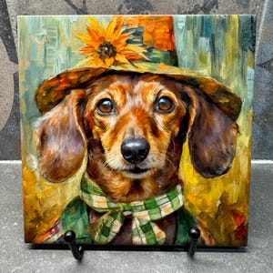 Puede incluir: Una pintura de un dachshund con un sombrero de paja con un girasol en la parte superior y una bufanda de cuadros verdes y blancos. El perro está mirando directamente al espectador.