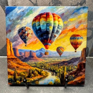 May include: A colorful painting of hot air balloons flying over a desert landscape. The sky is a vibrant blue with clouds, and the sun is setting in the distance. The balloons are red, yellow, blue, and green, and they are all different shapes and sizes. The desert landscape is brown and orange, with mountains in the distance.