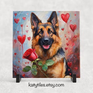 May include: A painting of a German Shepherd dog holding a red rose in its mouth. The dog is surrounded by red hearts and a light blue background. The painting is on a square tile with a black stand.