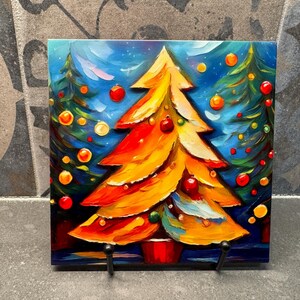May include: A colorful painting of a Christmas tree with red, yellow, and green ornaments. The tree is painted in a stylized, abstract style with thick brushstrokes. The background is a dark blue with white stars.